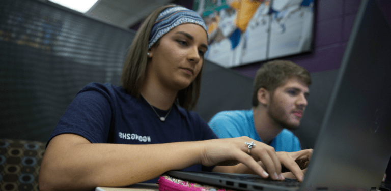 大学生在图书馆用笔记本电脑工作