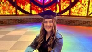 Lainey Burleson sits in Logsdon Chapel with her graduation cap.